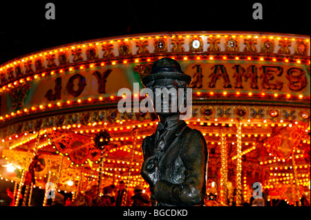 Die Statue von Charlie Chaplin in Leicester Square mit einem hellen Messegelände fahren hinter. Stockfoto