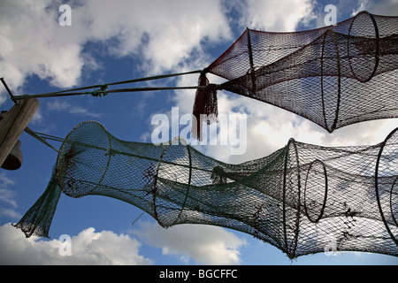 Trocknenden Fisch fangen Netze auf trocknen Boden vor blauem Himmel mit weißen Wolken. Stockfoto