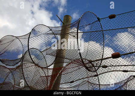 Trocknenden Fisch fangen Netze auf trocknen Boden vor blauem Himmel mit weißen Wolken. Stockfoto