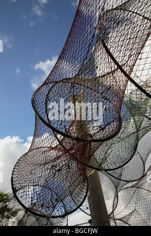 Trocknenden Fisch fangen Netze auf trocknen Boden vor blauem Himmel mit weißen Wolken. Stockfoto