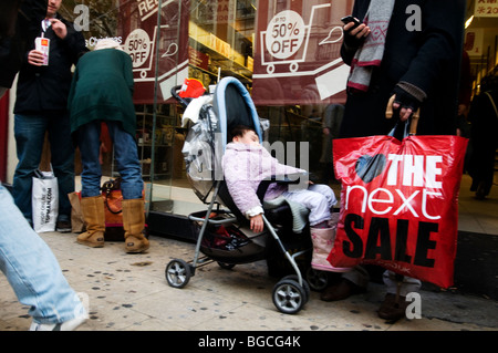 Oxford Street: Boxing Day 2009 Sales.Baby schlafend im Kinderwagen neben Vater mit nächsten Verkauf Tasche. Stockfoto