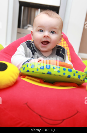 3 - 4 Monate alten Jungen spielen mit Spielzeug in Wiege Stuhl Stockfoto