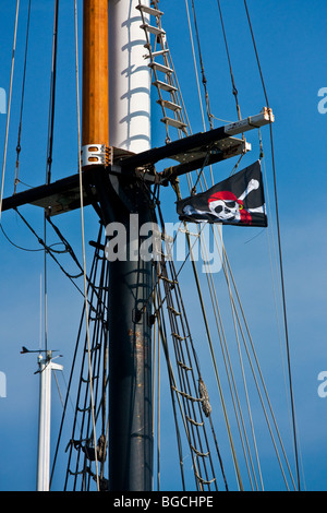 Piratenflagge am Mast eines Schiffes angehoben Stockfoto