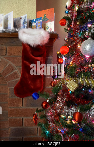 leere Weihnachts-Strumpf hängen unter der Zeile der Weihnachtskarten auf einem Kaminsims in ein Weihnachtsfest eingerichtete Wohnzimmer im Vereinigten Königreich Stockfoto