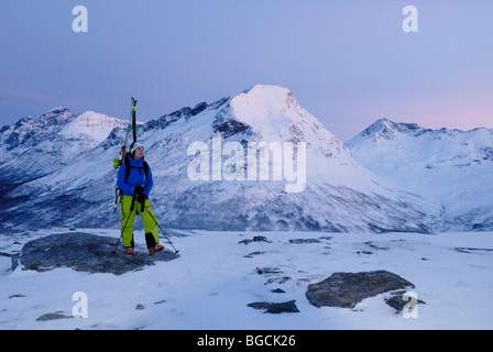 Feine rosa und blauen arktischen Midwinter Licht in der Nähe von Mittag, Skifahrer, Klettern auf Andersdalstinden Berg in der Nähe von Tromsø, Norwegen Nord Stockfoto