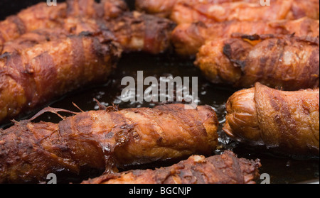 Speckmantel Würstchen in England bekannt als Schweinchen in Decken, frisch aus dem Ofen in Zinn mit flachen Fokus rösten. Stockfoto