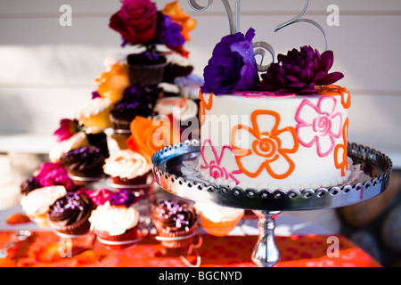 Hochzeitstorte auf silbernen Tablett mit Cupcakes dekoriert Stockfoto