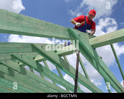 Tischler, fahren einen Nagel in Haus Sparren Rahmung Strahl Stockfoto