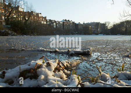 Winterschnee und Eis auf zugefrorenen Teich auf Hampstead Heath in London England uk Stockfoto