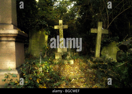 Grabsteine und Unterholz in Highgate Cemetery in London England UK Stockfoto