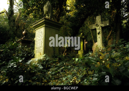 Grabsteine und Unterholz in Highgate Cemetery in London England UK Stockfoto