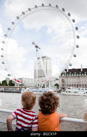 25. Juli 2009 zwei jungen Blick auf London Eye, auch bekannt als Millennium Wheel am Ufer der Themse, London, England. Stockfoto