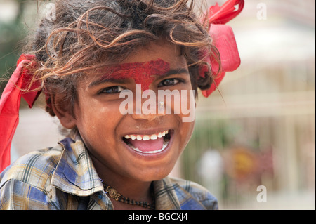 Sehr schlechte ziemlich indische Zigeunerin lächelnd mit roten Schleifen im Haar. Selektiven Fokus. Stockfoto