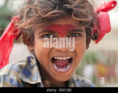 Sehr schlechte ziemlich indische Zigeunerin lächelnd mit roten Schleifen im Haar. Selektiven Fokus. Stockfoto