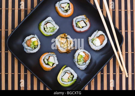 Verschiedene Sushi rollt auf schwarzem Teller, schließen Stockfoto