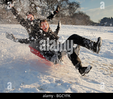 Jungs im Teenageralter Schlittenfahren im Schnee. Stockfoto