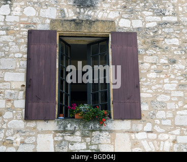 Dordogne-Fenster mit Fensterläden und Blumen in Topfpflanzen Stockfoto