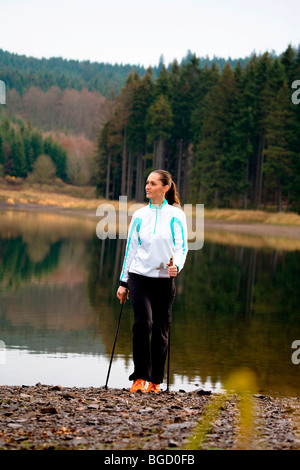 Junge Frau tun, Nordic-walking am See Stockfoto