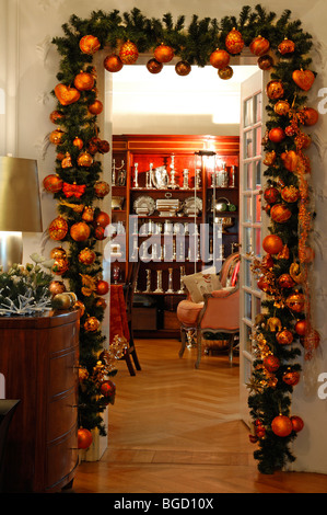 Tür mit Tannenzweigen verziert und Weihnachtskugeln, Blick in eine Vitrine mit Besteck, Villa & Ambiente Shop, Stockfoto