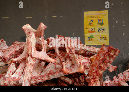 Tierknochen eines Metzgers vor Anzeige für Hygiene im muslimischen Viertel von Xian, Shaanxi, China, Asien Stockfoto