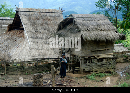 Armut, Akha Nuqui Frau gekleidet in traditioneller Kleidung, strohgedeckten Hütten, Dorf Ban Paycho, Provinz Phongsali und dis Stockfoto