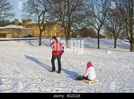 Schnee und Schlittenfahren, Heaton Park (Dezember 2009), Manchester, UK. Heaton Hall im Hintergrund. Stockfoto