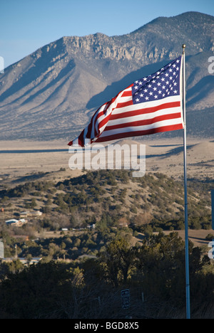 Mit Carrizo Berg als Kulisse Flagge ein Veteran stolz über der kleinen Stadt Nogal, New Mexico. Stockfoto