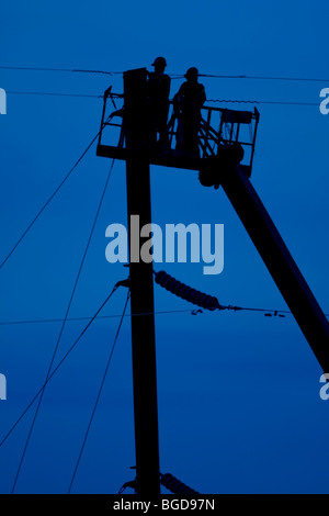 Elektrische Linemen Arbeiten aus einem Eimer auf Stromleitungen Stockfoto