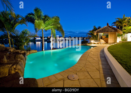 Luxuriöses Herrenhaus Fassade bei Sonnenuntergang mit Blick auf Pool und Kanal Bali Hütte Stockfoto