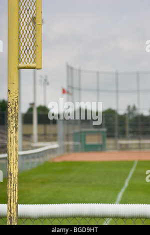 Hinter dem Zaun der Feldspieler, die Foul-Linie auf der linken Seite, auf der Suche nach der ersten Grundlinie in Richtung einer leeren Baseballfeld Stockfoto