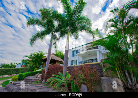 Garten mit Palmen und Bali Hütte vor Waterfront Villa Stockfoto