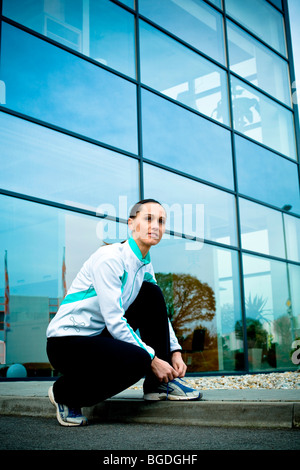 Junge Frau, die eine Pause beim Joggen Stockfoto