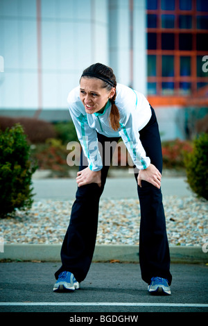 Junge Frau, die eine Pause beim Joggen Stockfoto