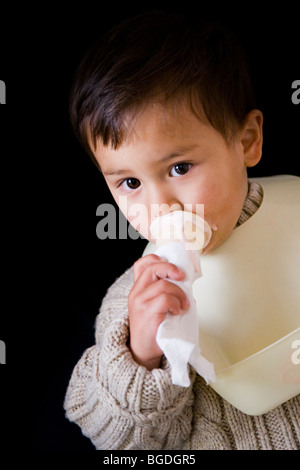 21 Monate O. junge essen Eis aus einem Kegel. Stockfoto