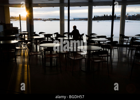 Person, die den späten Mittag Sonnenaufgang in einem Café zu beobachten. Rathaus von Reykjavik, Island. Stockfoto