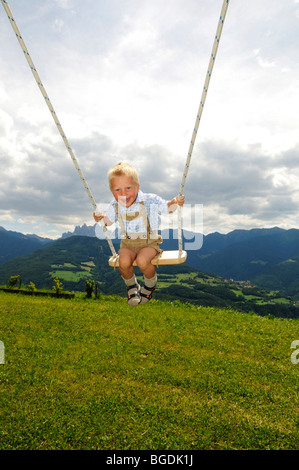 Junge auf einer Schaukel Geisler Gruppe, Dolomiten, Südtirol, Italien, Europa Stockfoto