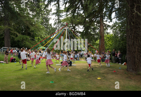 Kinder von Church Preen Schule genießen Sie die traditionelle kann Pole Dance. Stockfoto