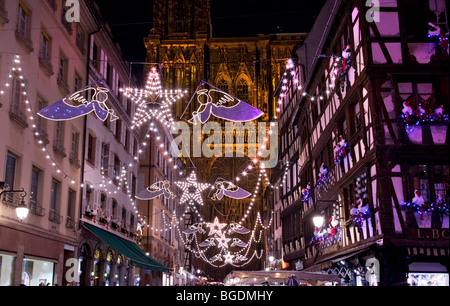 Weihnachtsbeleuchtung in den Straßen von Straßburg mit dem Dom im Hintergrund und Altholz Gebäude. Stockfoto