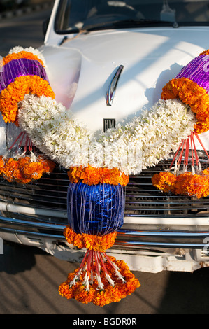 Traditionelle hinduistische Blumenkranz auf der Motorhaube eines indischen Taxi. Andhra Pradesh, Indien Stockfoto