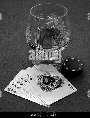 Schwarz / weiß Royal Flush mit Poker-Chips und ein Glas eines Geistes. Stockfoto