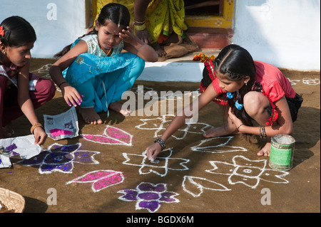 Ländlichen indischen Dorf Mädchen einen rangoli Design in einem ländlichen indischen Dorf während des Festivals von sankranthi. Andhra Pradesh, Indien. Selektiver Fokus Stockfoto