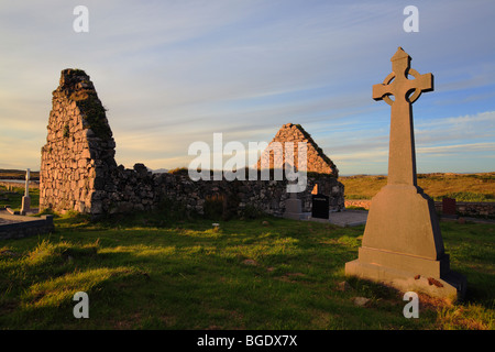 Friedhof Carna in der Nähe von Galway und Roundstone mit Keltenkreuz und dachlose Kirche bei Sonnenuntergang, Connemara, Irland Stockfoto