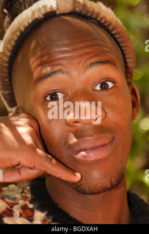 Traditionell gekleideten südafrikanischen Zulu Jüngling Blick in die Kamera überraschend. Am Telefon sprechen. Südafrika, Nov.2009 Stockfoto