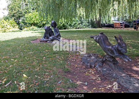 Bronze-Statue von Alice im Wunderland beobachten, wie das weiße Kaninchen laufen für die Öffnung von Fluß Wey in Guildford, Surrey, England Stockfoto