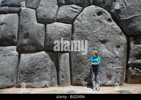 Frau stand vor dem riesigen Steinen von Sacsayhuamán außerhalb Cusco in Peru Stockfoto