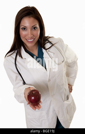 Junge attraktive freundlich dreißiger Jahre hispanic Frau Doktor hält Apfel Stockfoto