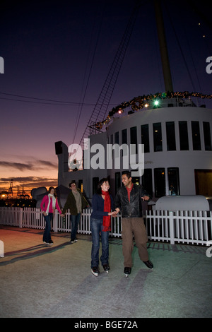 Freunde-Eislaufen auf eine synthetische Eisbahn an Bord der Queen Mary in Long Beach, CA, USA Stockfoto