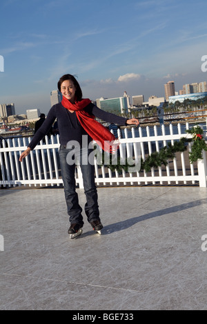 Frau-Eislaufen auf eine synthetische Eisbahn an Bord der Queen Mary Hotel und Attraktion in Long Beach, Kalifornien Stockfoto