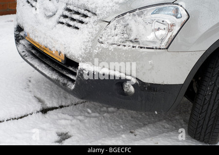 Detail eines Schnee bedeckten Autos parkten an der Seite einer Straße Stockfoto