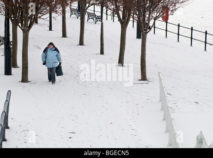 Eine Frau, einen überdachten Weg Schnee durch den Kanal in Salford Quays in Manchester, England, UK Stockfoto